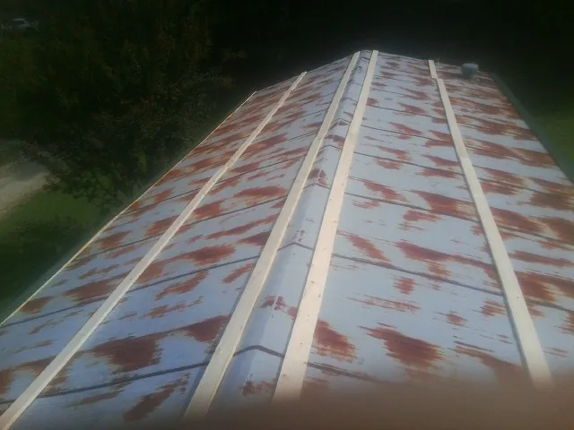 Rusted metal roof panels with new wood purlins before replacement — Storm Damage Roof Repair in Hooppole by Roofing Brothers
